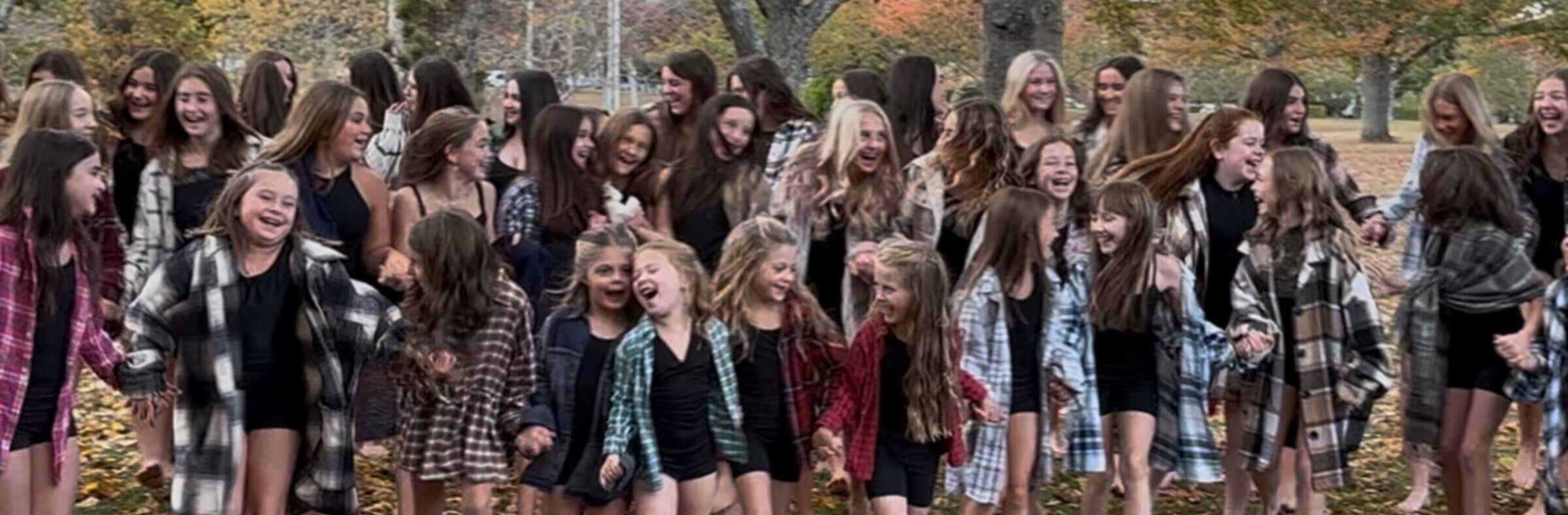 The whole studio laughing together outdoors in matching flannel shirts