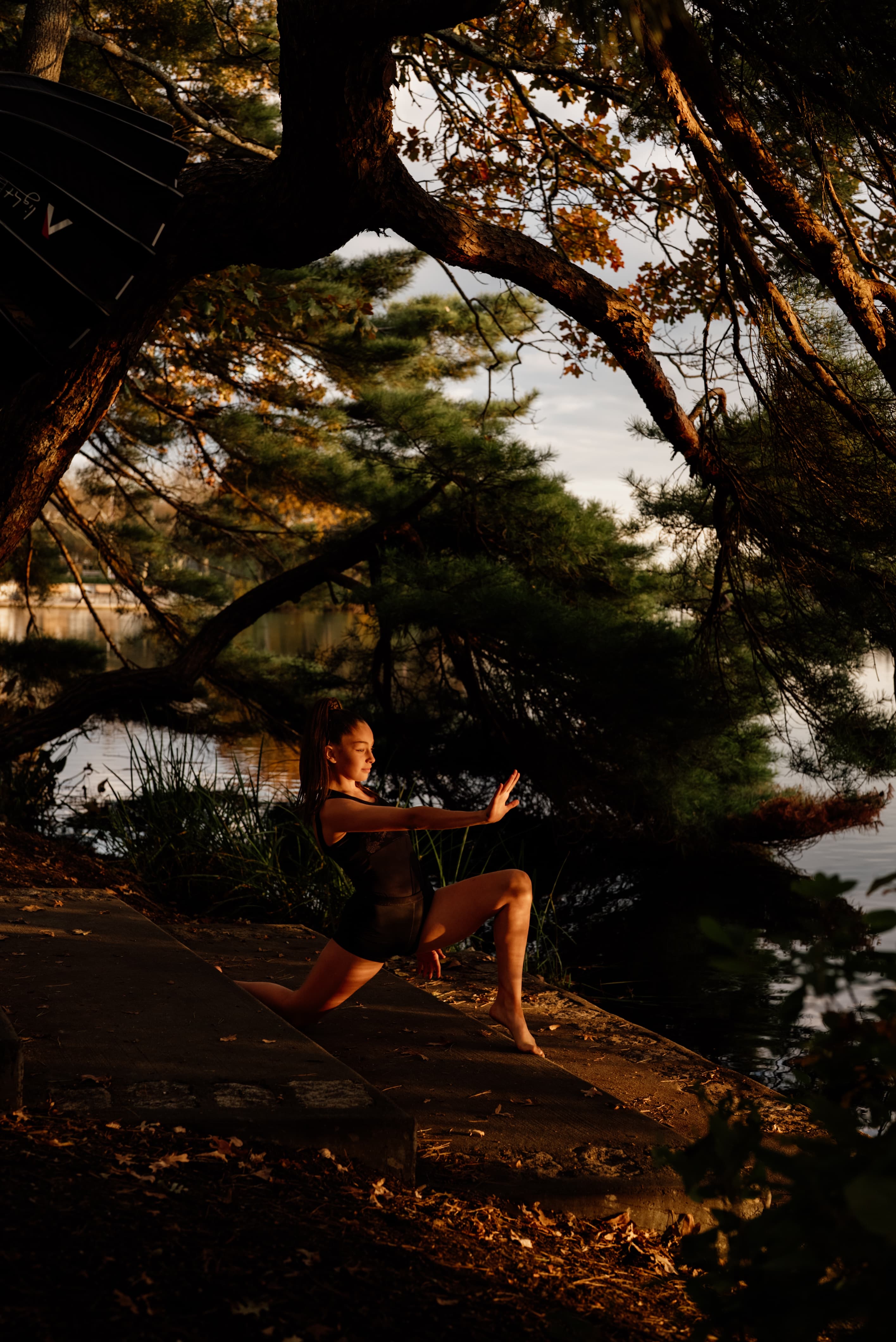 Dancer in a sharp lunge with palm outstretched outdoors