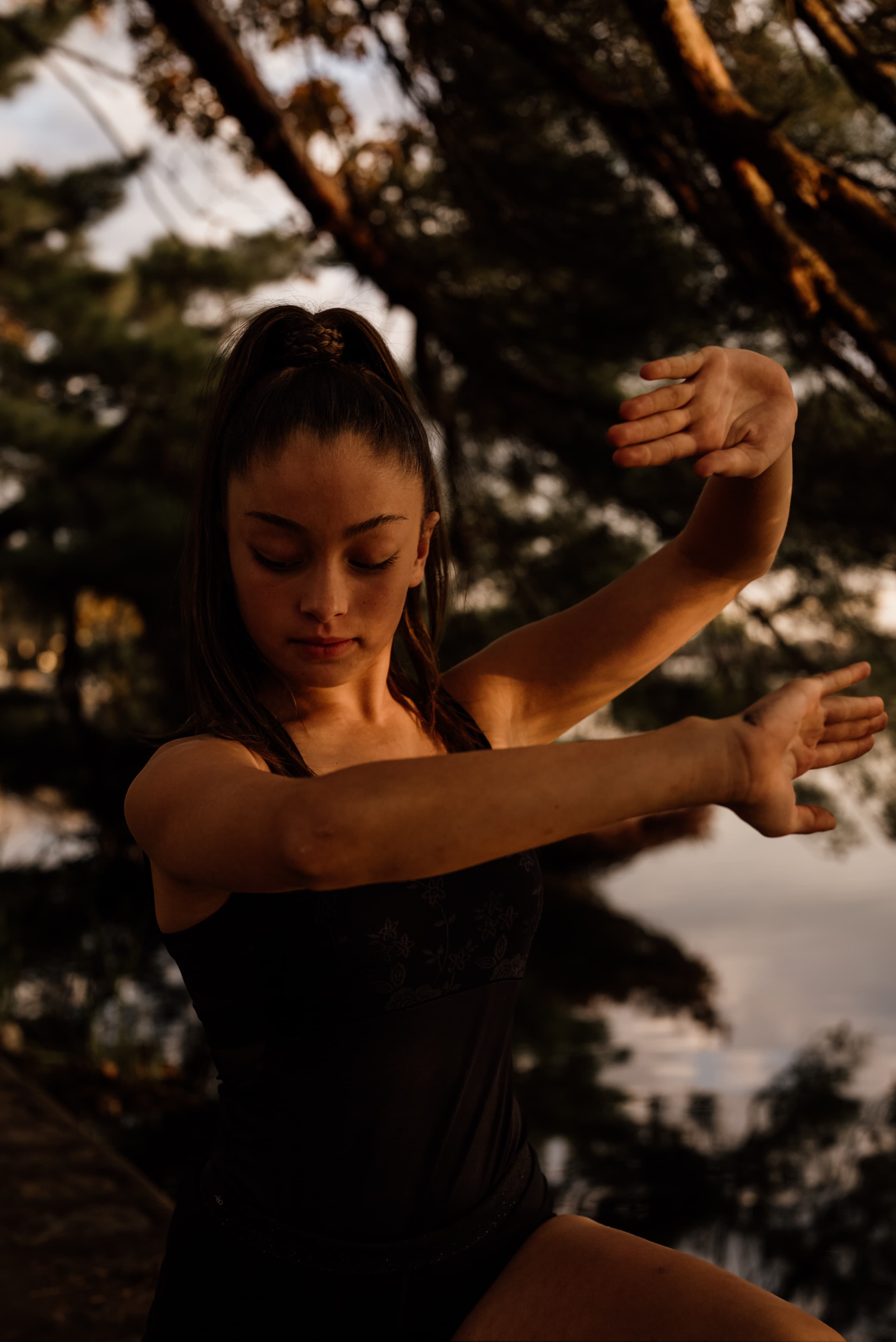 Dancer in an intense, mindful reaching pose outdoors
