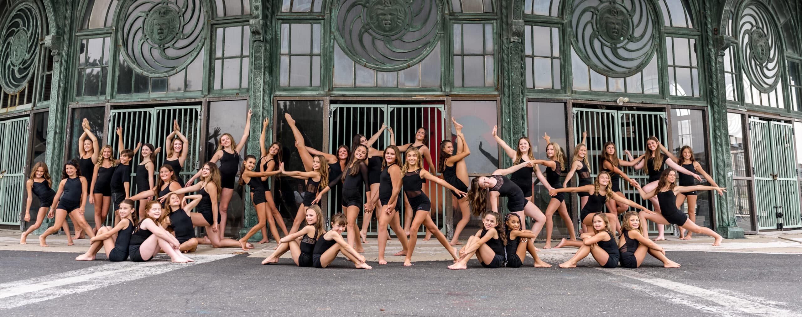 Company dancers posing together outside the ornate Asbury Park Carousel House